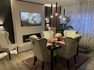 Renovierter Essbereich mit TV-Wand und Holzlamellen